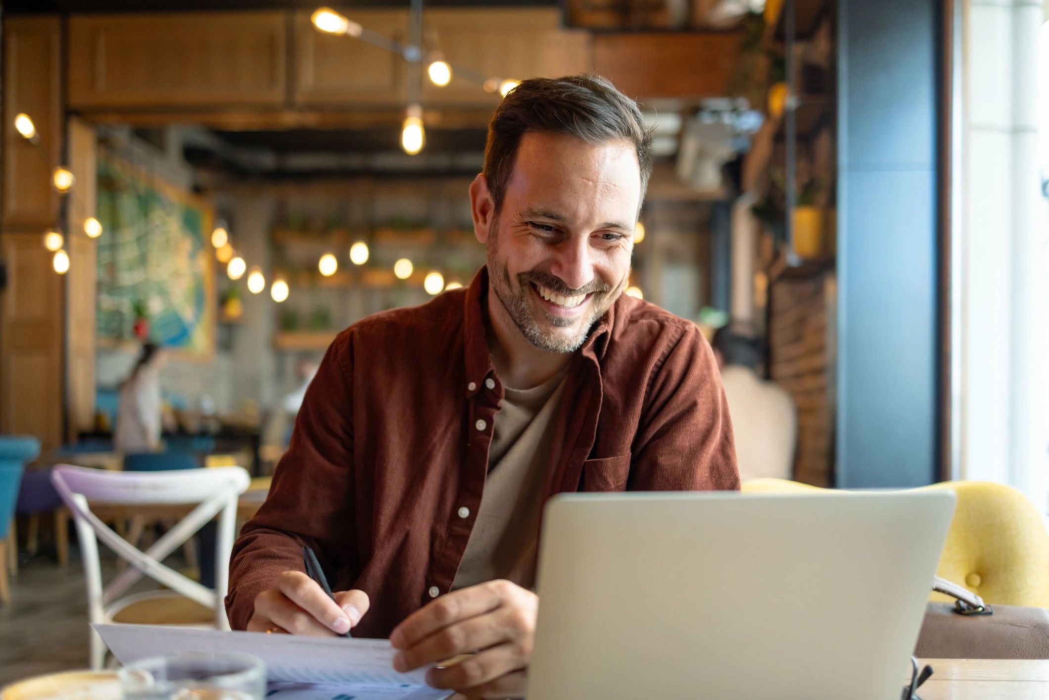 Journalist working on a laptop with notebook and coffee