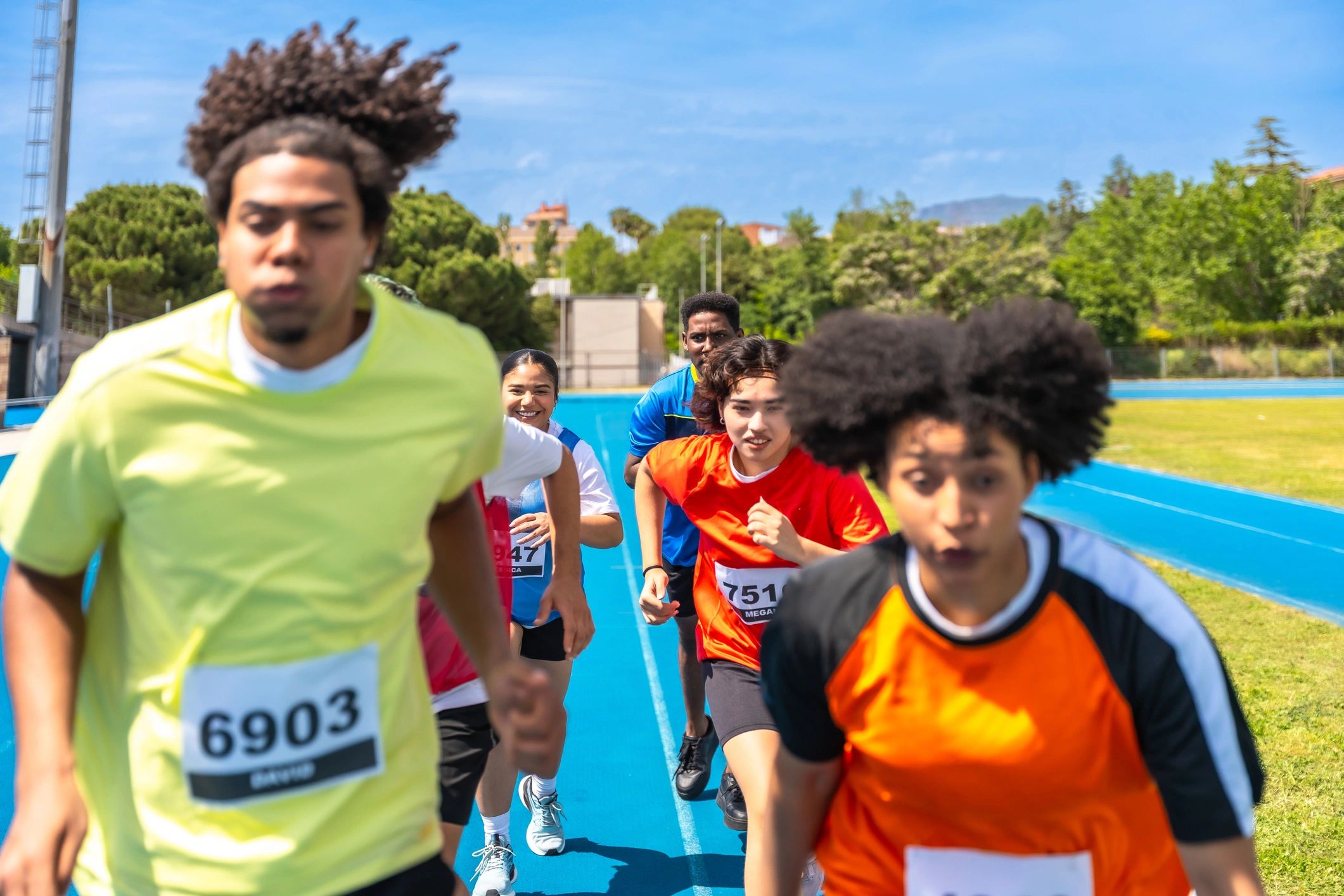 Athletes sprinting on a blue track