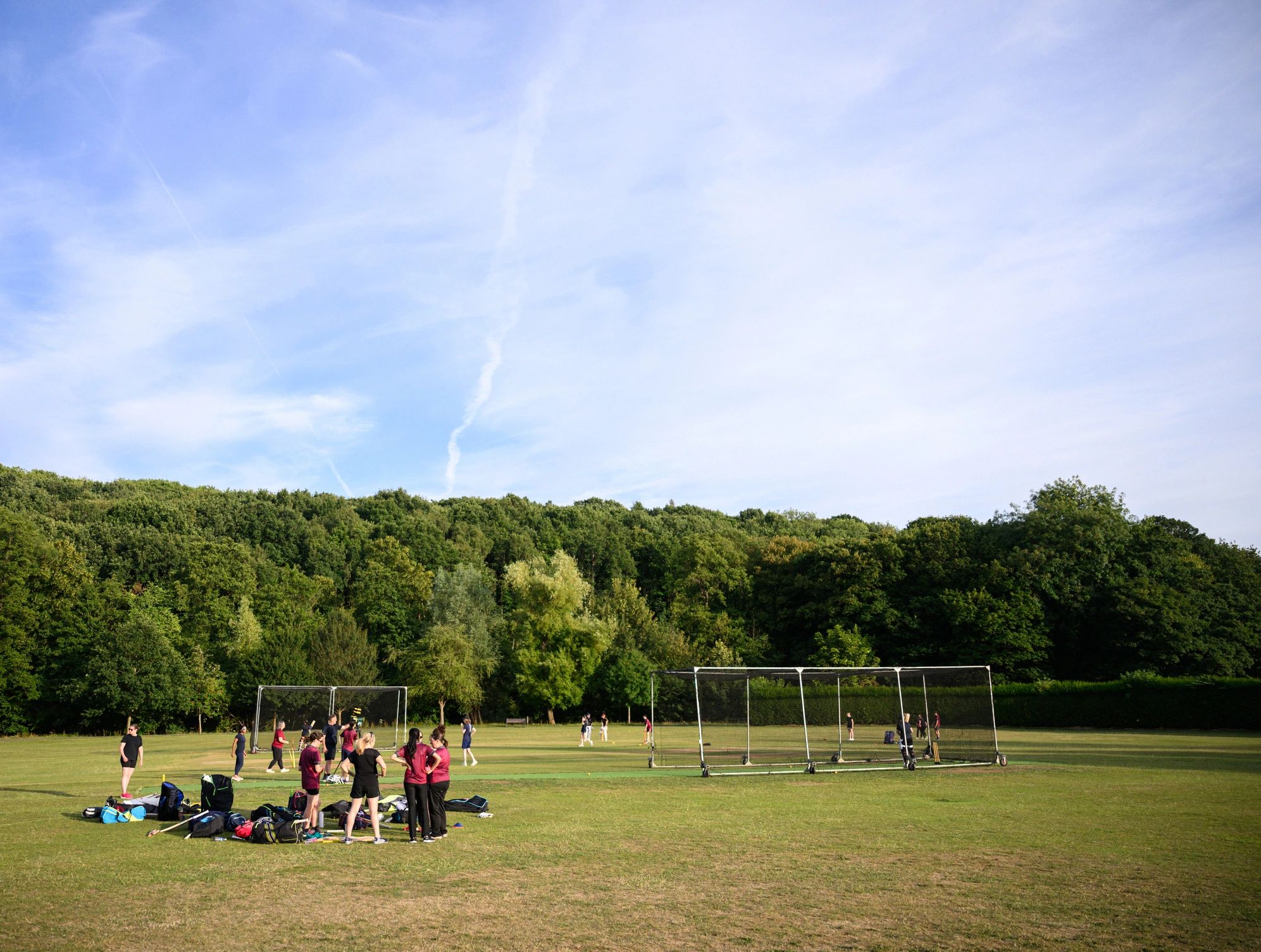 Women practicing cricket on a field