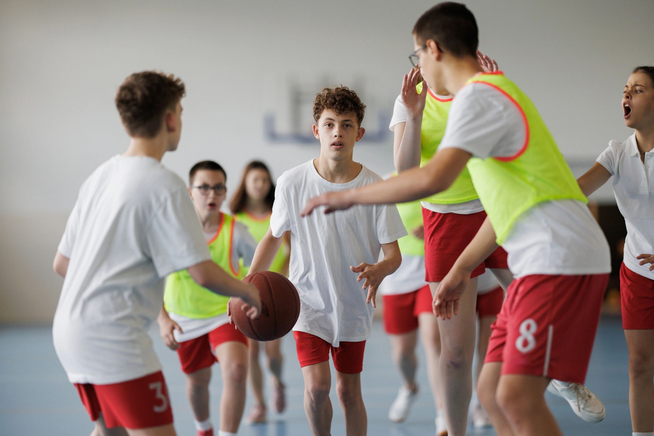 Basketball game action in a gym